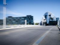 a man is riding a skateboard down the road in front of some large buildings