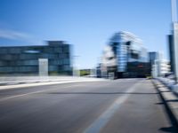 a man is riding a skateboard down the road in front of some large buildings