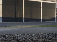 man riding on skateboard in front of tall building with shutters on each side