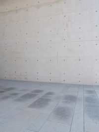 a man on a skateboard stands outside of an empty building and looks out from a glass entrance