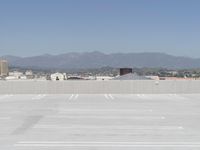 a man flying a kite while on his skateboard in the air outside an airport