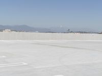 a man flying a kite while on his skateboard in the air outside an airport