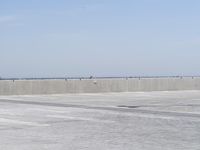 a man flying a kite while on his skateboard in the air outside an airport