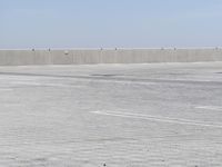 a man flying a kite while on his skateboard in the air outside an airport