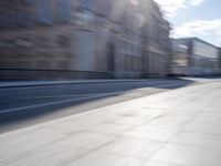 a man is riding a skateboard down a city street in front of a building