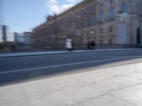 a man is riding a skateboard down a city street in front of a building