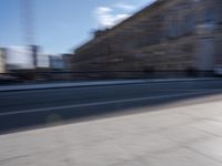 a man is riding a skateboard down a city street in front of a building