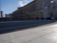 a man is riding a skateboard down a city street in front of a building