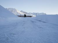 a man walking down the side of a snowy slope as he skis on a track