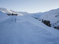 a man walking down the side of a snowy slope as he skis on a track