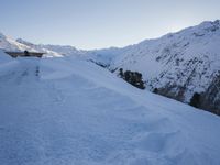 a man walking down the side of a snowy slope as he skis on a track