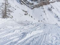 a man riding a snowboard down the side of a ski slope while holding onto a pole