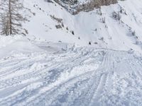 a man riding a snowboard down the side of a ski slope while holding onto a pole