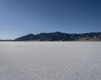 a man is standing in the desert with a remote control kite behind him that looks like he's in the middle of the frame