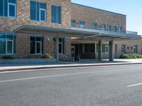 a man is walking in front of the building at a cross walk station with no cars