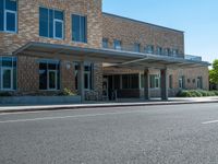 a man is walking in front of the building at a cross walk station with no cars