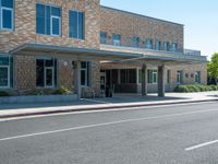 a man is walking in front of the building at a cross walk station with no cars