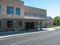 a man is walking in front of the building at a cross walk station with no cars