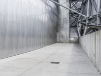 a man with a helmet and black jacket is walking near a wall of metal walls