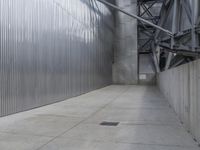 a man with a helmet and black jacket is walking near a wall of metal walls