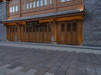 a man walks through the sidewalk of an old chinese city street at night of twilight