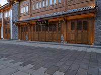 a man walks through the sidewalk of an old chinese city street at night of twilight