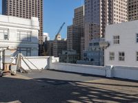 the man is walking down a rooftop with a cart behind him and buildings beyond them