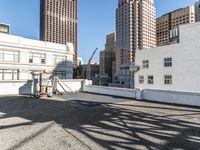 the man is walking down a rooftop with a cart behind him and buildings beyond them