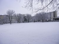 a man is walking through the snow in a large open field with lots of trees