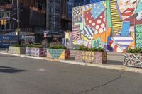 a man is walking down the street in front of an artistic wall and building with colorful graffiti