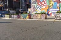 a man is walking down the street in front of an artistic wall and building with colorful graffiti