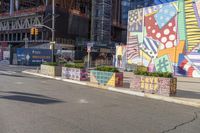 a man is walking down the street in front of an artistic wall and building with colorful graffiti