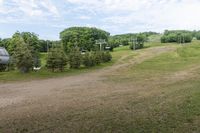 an image of a man standing in the field watching a ski lift move in front