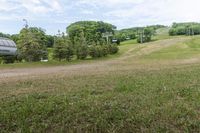 an image of a man standing in the field watching a ski lift move in front