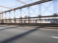 a person on a motorcycle crossing a bridge that is mostly empty and clear of traffic