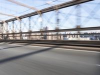 a person on a motorcycle crossing a bridge that is mostly empty and clear of traffic