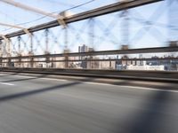 a person on a motorcycle crossing a bridge that is mostly empty and clear of traffic