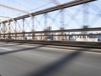 a person on a motorcycle crossing a bridge that is mostly empty and clear of traffic