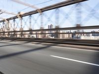 a person on a motorcycle crossing a bridge that is mostly empty and clear of traffic