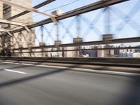 a person on a motorcycle crossing a bridge that is mostly empty and clear of traffic