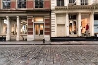 a store front that is bricked in with red bricks on the sidewalk in front of it