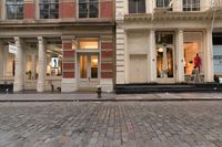 a store front that is bricked in with red bricks on the sidewalk in front of it