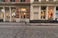 a store front that is bricked in with red bricks on the sidewalk in front of it