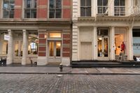 a store front that is bricked in with red bricks on the sidewalk in front of it