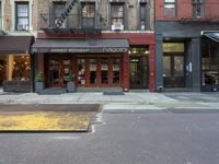 the city is full of different businesses and buildings, as well as a sidewalk with an open fire hydrant