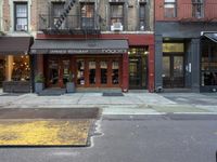 the city is full of different businesses and buildings, as well as a sidewalk with an open fire hydrant