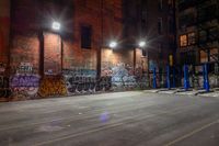 some graffiti and bicycle parking along the street in the dark night time area of an urban city