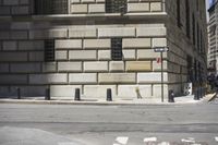 the man is walking on the sidewalk in the city setting and crossing the street corner