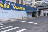 this is an image of a car wash shop on a city street corner in the afternoon