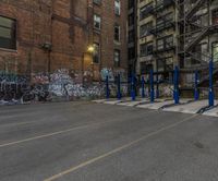 a street corner with several parking lot stands by graffiti covered buildings and staircases above